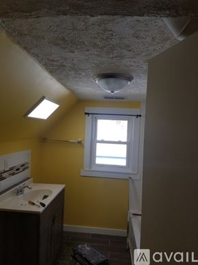 Terre Haute house for rent - A bathroom with yellow walls and a window.