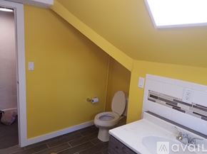 Terre Haute house for rent - A bathroom with yellow walls and a white toilet.