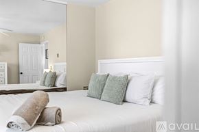 San Diego condo for rent - A bedroom with a white bed and a mirror on the wall.