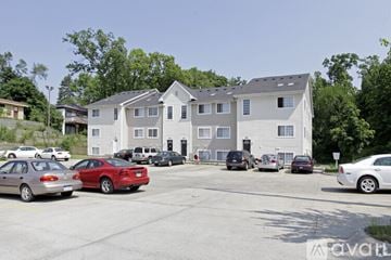 Kalamazoo apartment for rent - A parking lot with cars and a building in the background.
