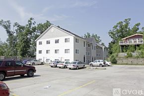 Kalamazoo apartment for rent - A parking lot with cars and a building in the background.