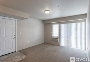 Spokane Valley apartment for rent - A room with a carpeted floor and a window with blinds.
