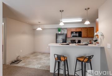 Spokane Valley apartment for rent - A kitchen with a bar stool and a fridge.
