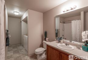 Spokane Valley apartment for rent - A bathroom with a toilet, sink, and mirror.