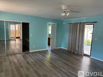 St. Petersburg house for rent - A spacious room with a ceiling fan and sliding glass doors.