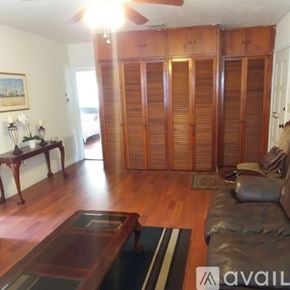 Coral Gables house for rent - A room with a wooden floor and a ceiling fan.