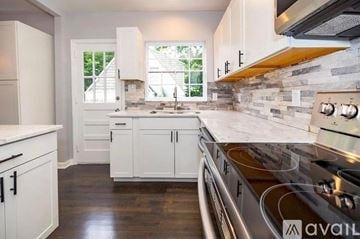 Atlanta house for rent - A kitchen with white cabinets and a stainless steel oven.