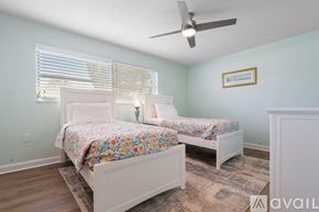 St. Pete Beach house for rent - A bedroom with two beds and a ceiling fan.