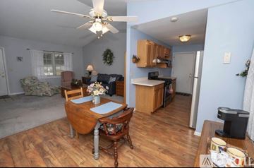 Granger house for rent - A woman is standing in a kitchen with a dining table and chairs.