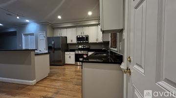 Washington house for rent - A kitchen with a black fridge and stove top oven.