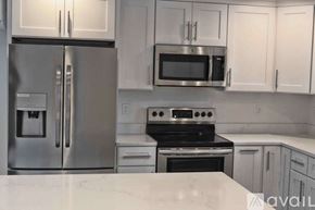 Tacoma townhouse for rent - A kitchen with a stainless steel refrigerator, microwave, and oven.