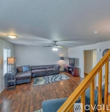 Laramie apartment for rent - A living room with a grey couch and a wooden floor.