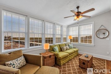 Savannah house for rent - A living room with a green couch and a fan on the ceiling.