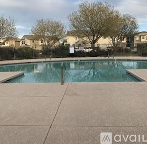 Goodyear townhouse for rent - A pool surrounded by a black fence with a sign that says "available" in the background.