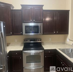 Goodyear townhouse for rent - A kitchen with dark wood cabinets and stainless steel appliances.