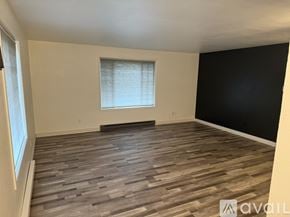 Slinger apartment for rent - A room with wooden flooring and a window with blinds.