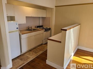 St. Helens apartment for rent - A kitchen with white cabinets and a wooden floor.