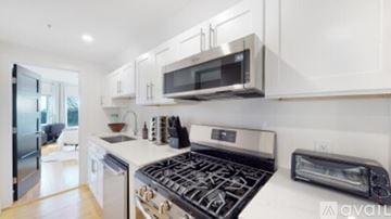 Waltham apartment for rent - A modern kitchen with a stove top oven and microwave above it.