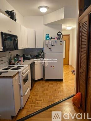 Waltham apartment for rent - A kitchen with a white fridge and stove top.