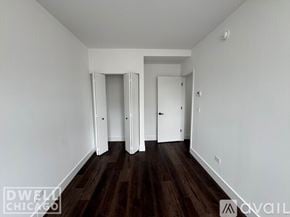 Chicago apartment for rent - A room with white walls and dark wood flooring, with a door on the right and another door in the middle of the wall.