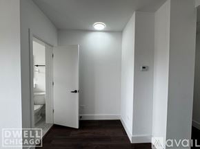Chicago apartment for rent - A white door is open to a bathroom in a white room.
