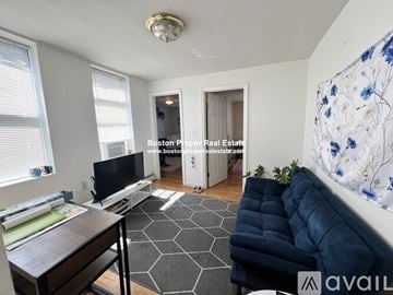 Boston apartment for rent - A living room with a blue couch and a television.