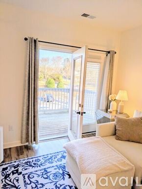 Charlotte condo for rent - A bedroom with a white couch and a blue patterned rug.