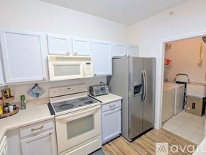 Charlotte condo for rent - A kitchen with white cabinets and appliances.