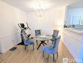 Charlotte condo for rent - A dining area with a table and chairs and a baby stroller.