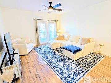 Charlotte condo for rent - A living room with a white couch and a blue rug.