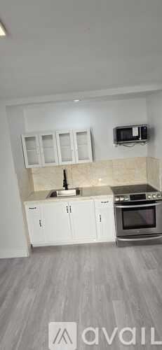 North Bergen apartment for rent - A kitchen with white cabinets and a microwave above the stove.