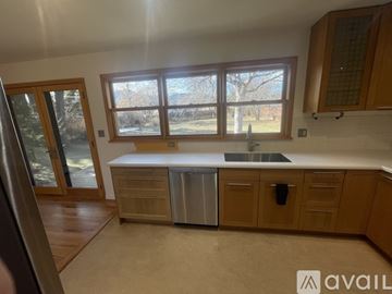 Winter Park apartment for rent - A kitchen with wooden cabinets and a window overlooking a tree.