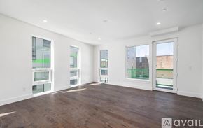 Winter Park apartment for rent - A spacious room with wooden floors and large windows.