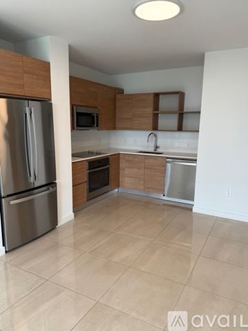 Miami apartment for rent - A kitchen with a refrigerator, microwave, oven, and sink.