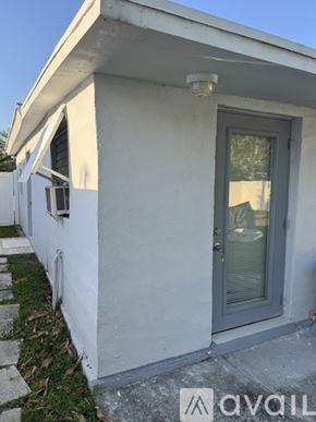 Miami apartment for rent - A white house with a grey door and a window.