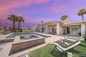 La Quinta house for rent - A house with a pool and a lawn chair in front of it.