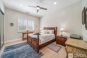 La Quinta house for rent - A bedroom with a large bed, a small bed, and a ceiling fan.