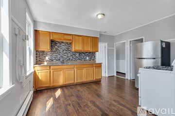 Providence apartment for rent - A kitchen with wooden cabinets and a stone backsplash.