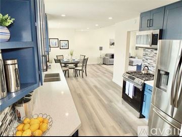 Pompano Beach apartment for rent - A kitchen with a refrigerator, sink, and dining table.