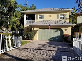 Fort Lauderdale townhouse for rent - A two-story house with a garage and a flag on the front.