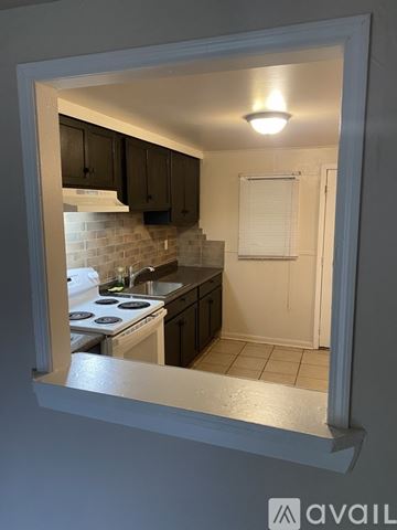 Baton Rouge house for rent - A kitchen with a stove and cabinets is visible through a window.