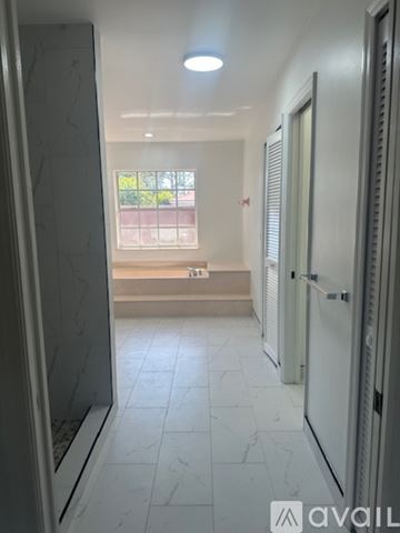 Port St. Lucie house for rent - A spacious room with a ceiling fan and sliding glass doors leading to a patio.