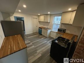 Pittsburgh apartment for rent - A kitchen with a black fridge and a black stove top oven.
