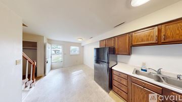 Salem apartment for rent - A kitchen with wooden cabinets and a black refrigerator.