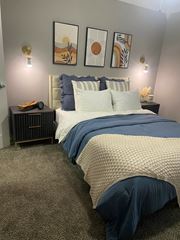 Dallas apartment for rent - A bedroom with a bed, nightstand, and wall art.