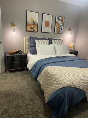 Dallas apartment for rent - A bedroom with a bed, nightstand, and wall art.