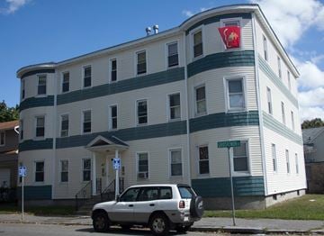 Worcester apartment for rent - A white car is parked in front of a blue and white building.