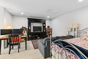 Morrisville house for rent - A bedroom with a bed, chair, and entertainment center.