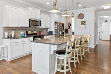 Morrisville house for rent - A kitchen with white cabinets and a granite countertop.