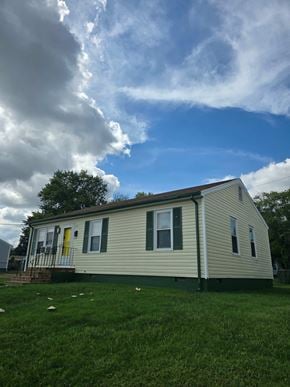 Richmond house for rent - A house with a green lawn and a yellow door.